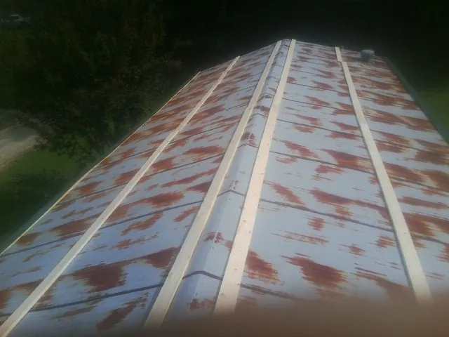 Rusted metal roof panels with new wood purlins before replacement — Storm Damage Roof Repair in Baldwinsville by Roofing Brothers