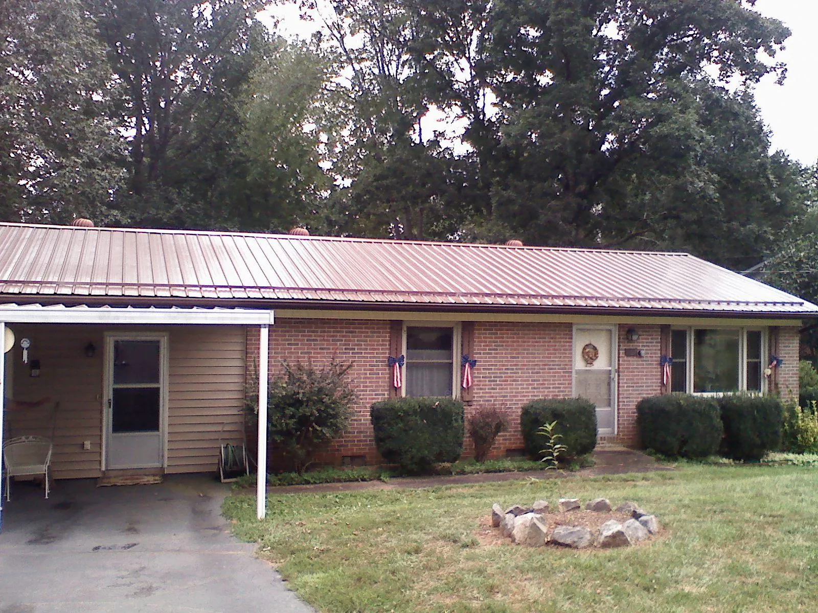 Bronze metal roof and carport on a brick ranch home — Roof Repair work by our crew in Baldwinsville